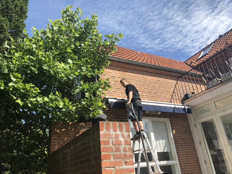 Montør på stige ved et villatag